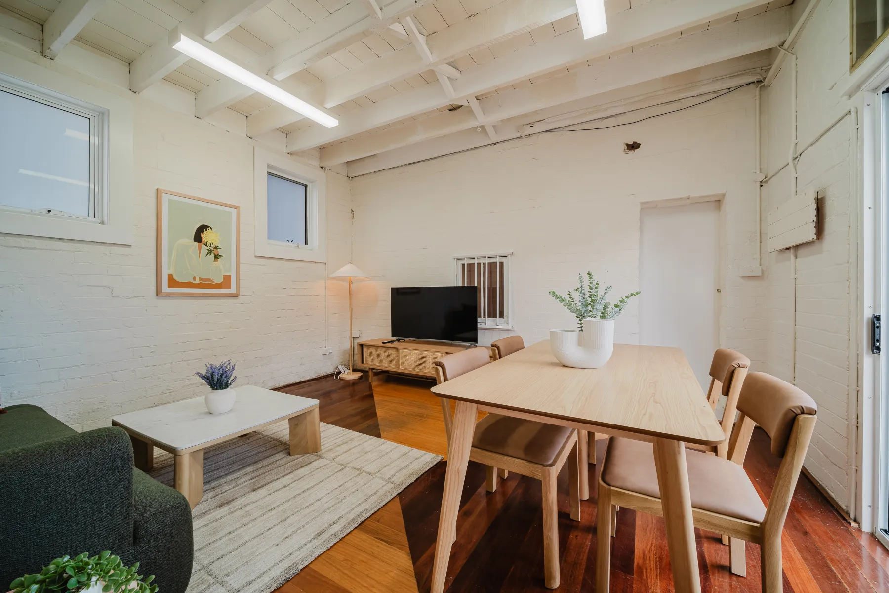 An airy studio living and dining space with timber floors at Sareh Balmain